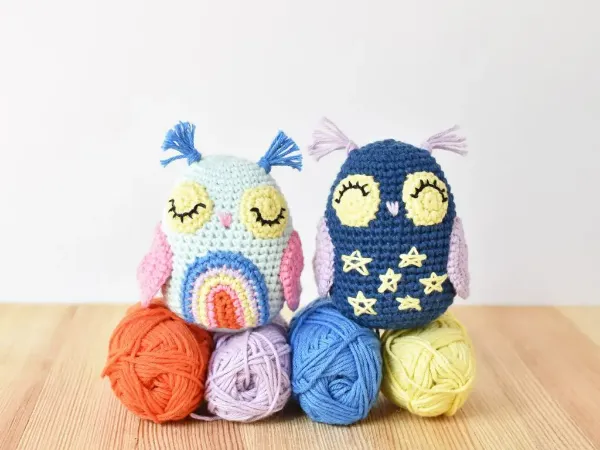 A day-themed owl with a rainbow coloured chest and a night time themed owl with stars in his chest.