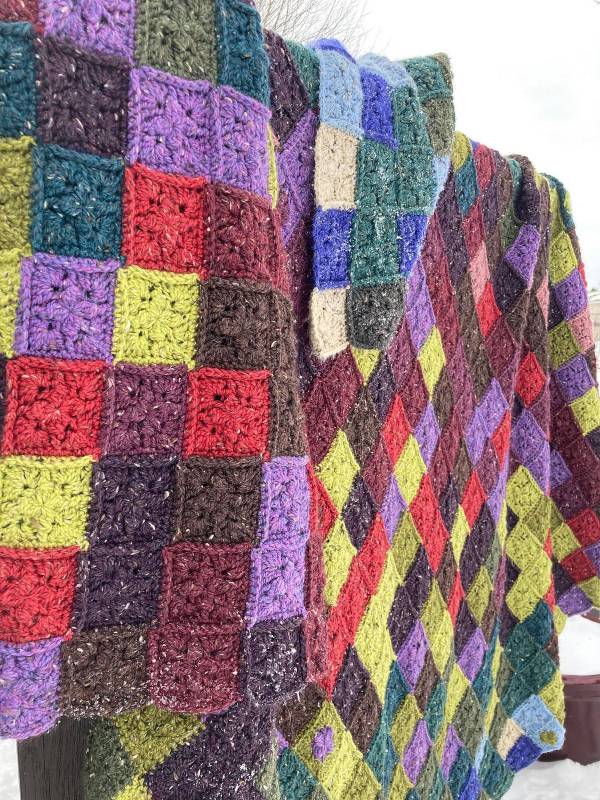 A temperature blanket made with mini crochet granny squares.