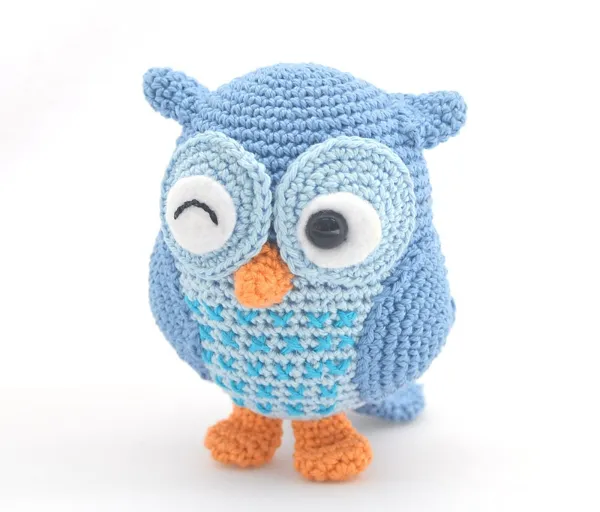 A winking crochet owl worked in shades of blue.