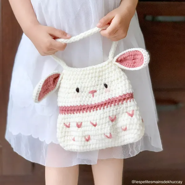 A child carrying a bunny-themed crochet bag.