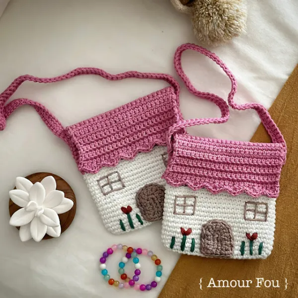 Two children's crochet bags in the shape of houses.