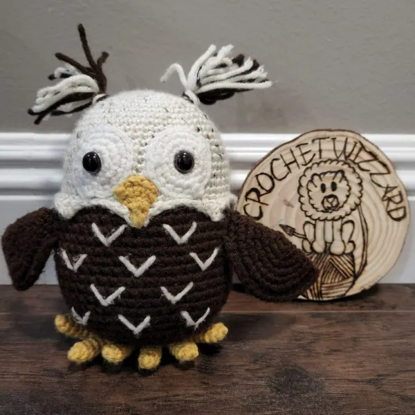 A dark brown crochet owl stuffie.