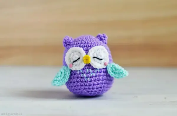 A purple and turquoise coloured mini crochet owl.