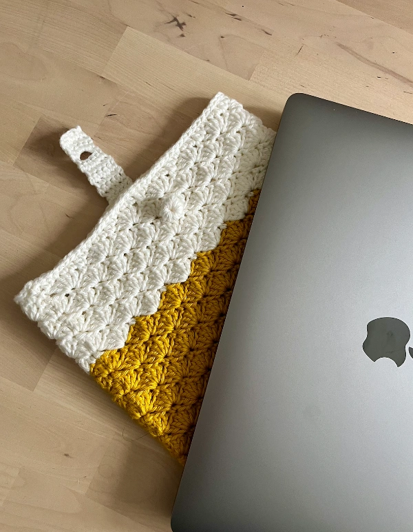 A colour-blocked crochet laptop cover in shell stitch.