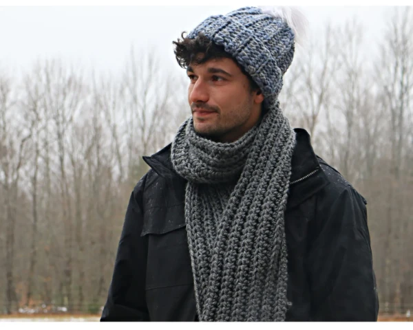 A man wearing a chunky ribbed crochet scarf.