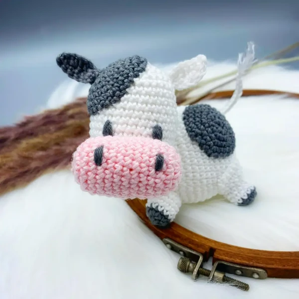 A mini crochet cow toy with a large head.