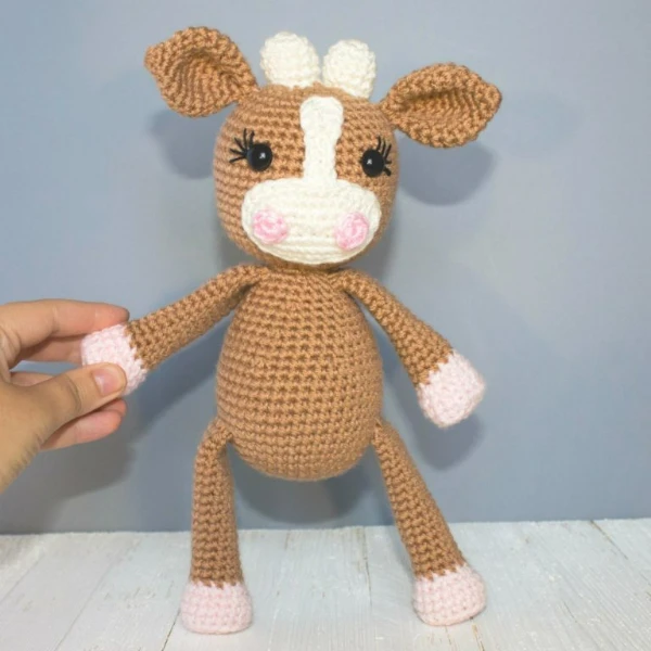 A pretty tan coloured crochet toy.
