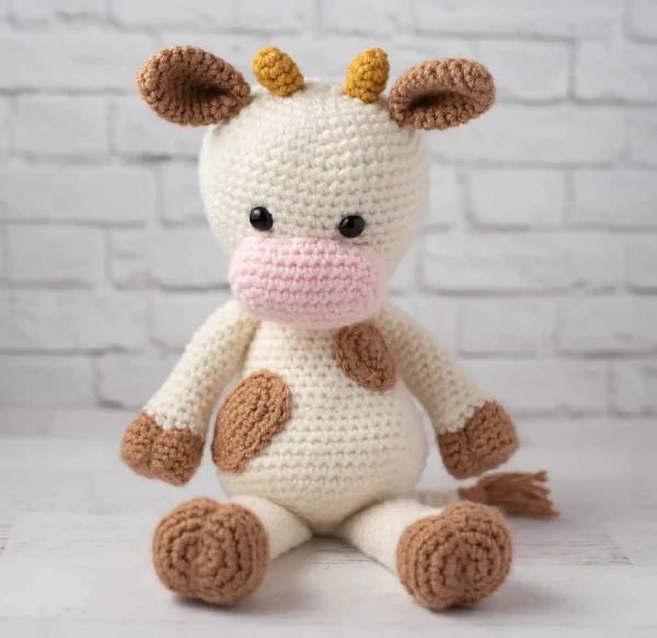 Caramel and white crochet cow toys.