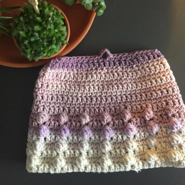 A simple tea cosy crocheted in variegated cotton yarn.