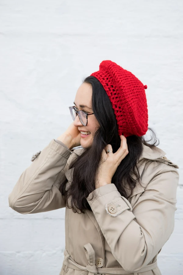 A woman wearing an easy-to-make red crochet beret.