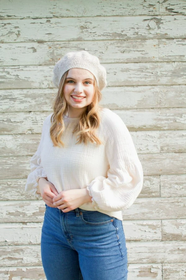 A you woman wearing a crochet french beret.