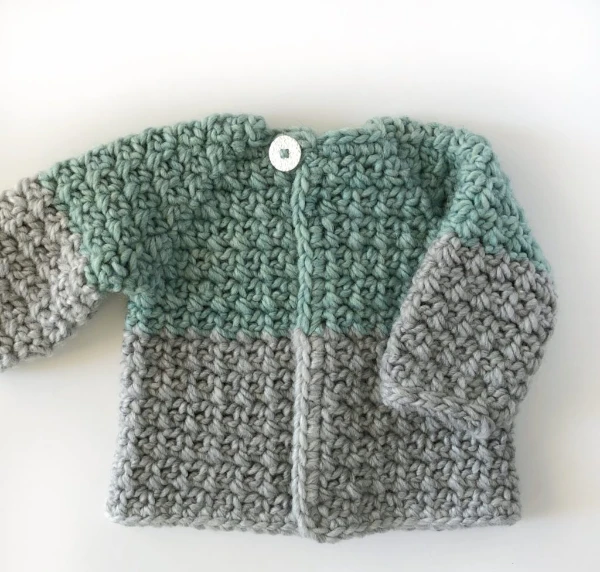 Two-tone mesh-stitch crochet newborn baby cardigan.
