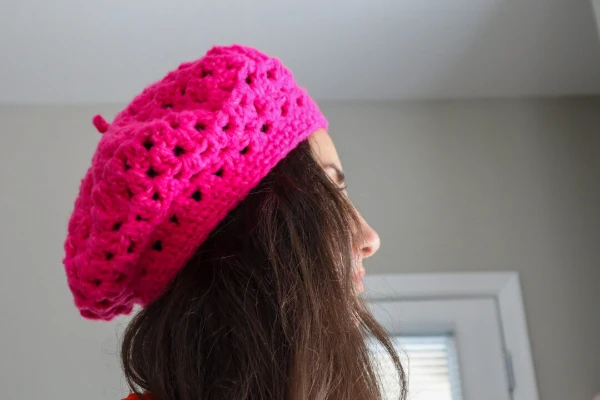 A bright pink cluster stitch crochet beret.