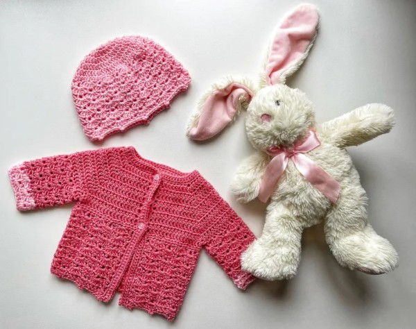 Bright pink newborn crochet cardigan and matching bonnet.