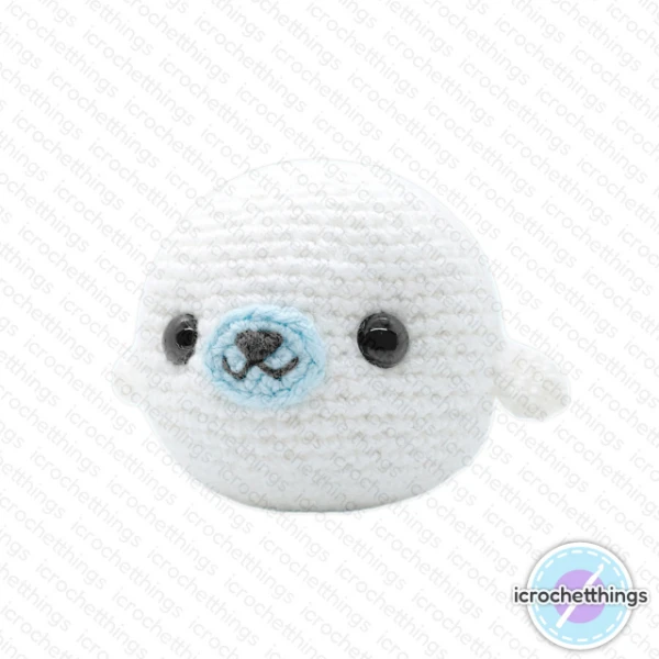 A round crochet seal toy with a blue nose.