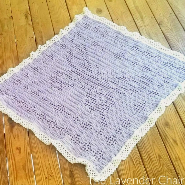 A lavender crochet baby blanket with a large butterfly motif.