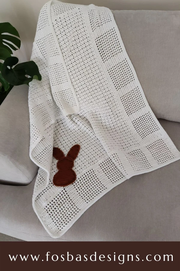 A lacy crochet baby blanket in white.