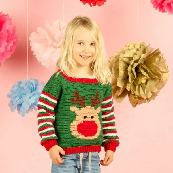 A child weating a crochet Christmas sweater with a reindeer motif.