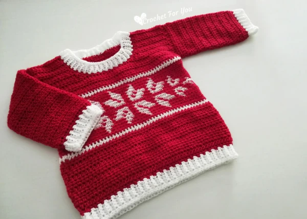 A red and white crochet Christmas sweater featuring snowflake motifs.