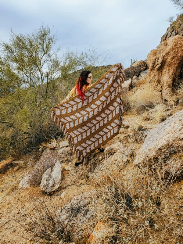 A two-colour tapetry crochet blanket with a wheat-ear design.