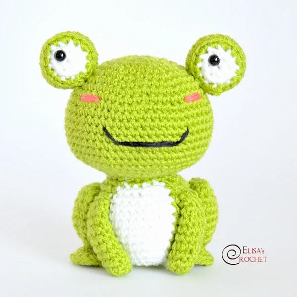A crochet baby frog with googly eyes.