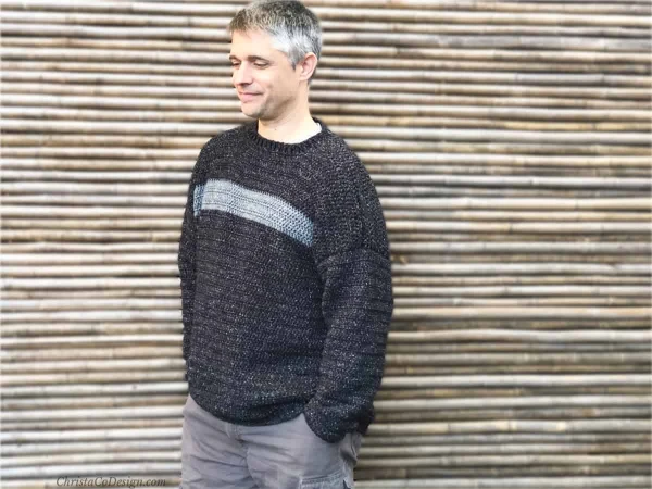 Man wearing a striped crewneck crochet sweater.