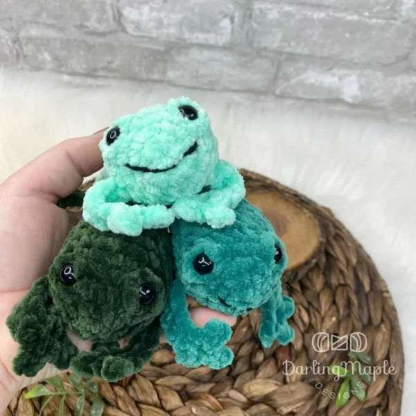 Three crochet frog plushies.