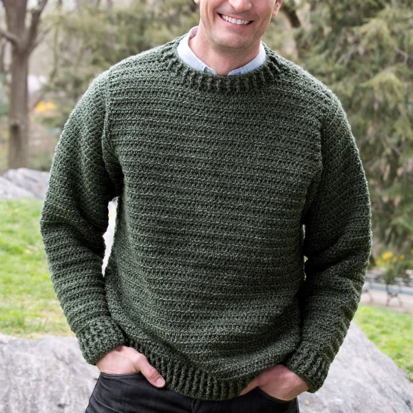 A man wearing a crochet crewneck pullover.