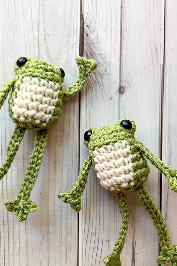 Two leggy crochet frogs.