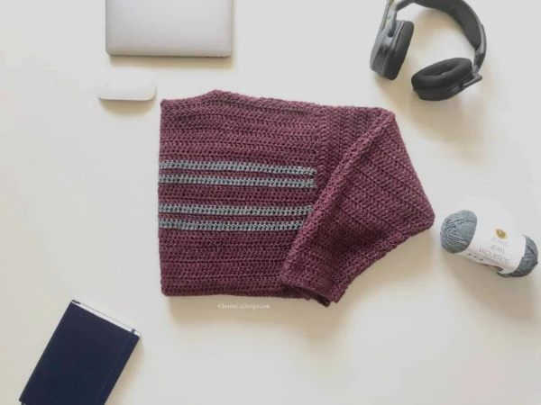 A flat lay image of a men's crochet sweater.