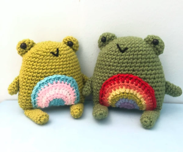 Crochet frogs with rainbow bellies.