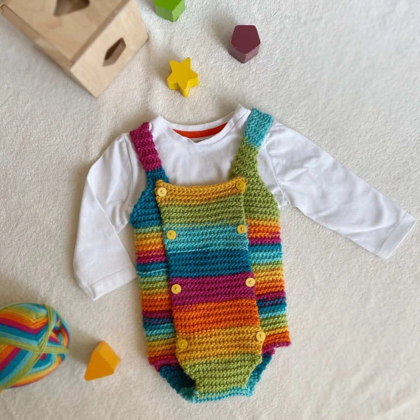 Aflat lay image of a brightly coloured crochet baby romper.