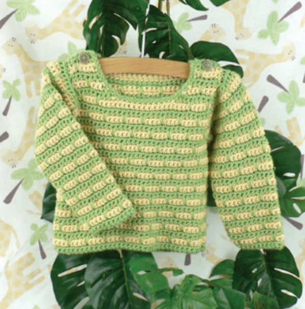 A green and yellow crochet baby seater on a wooden hanger.