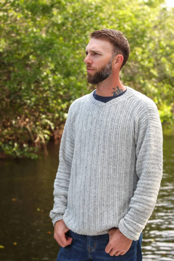 Man wearing a crochet V-neck sweater.