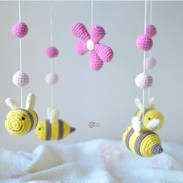 A nursery mobile with cute crochet bees and flowers.