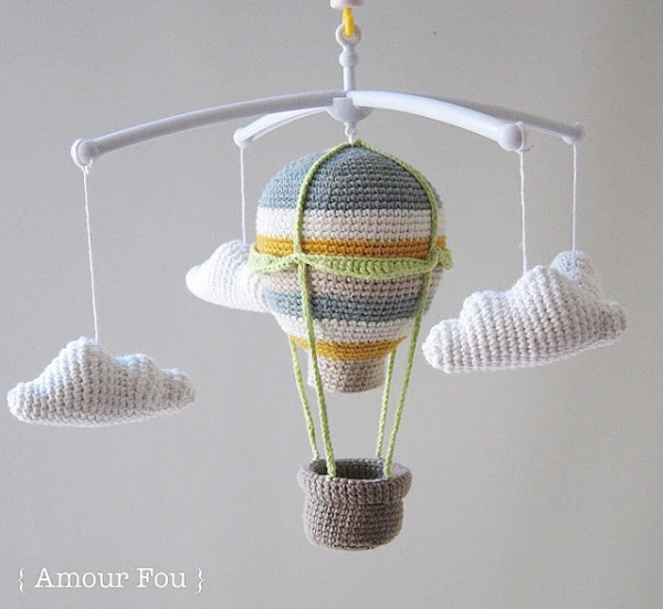 A crib mobile with a hot-air balloon and clouds.