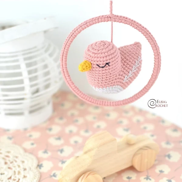 A pink crochet bird mobile.