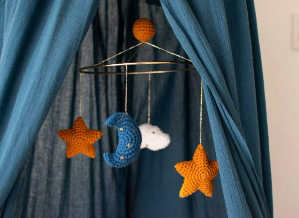 A crochet cot mobile with moon and stars.