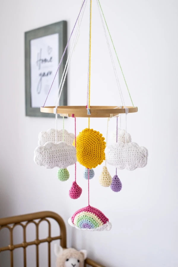 A rainbow-themed crochet crib mobile.