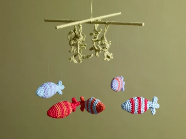 A sea-themed crochet mobile with fish and seaweed.