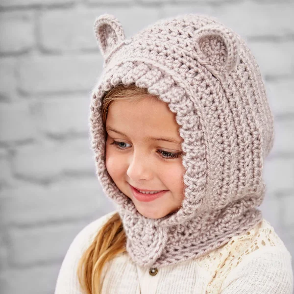 A child waering a hooded crochet cowl with ears.