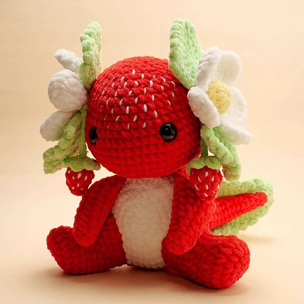 An amigurumi axolotl toy made to look like a strawberry.