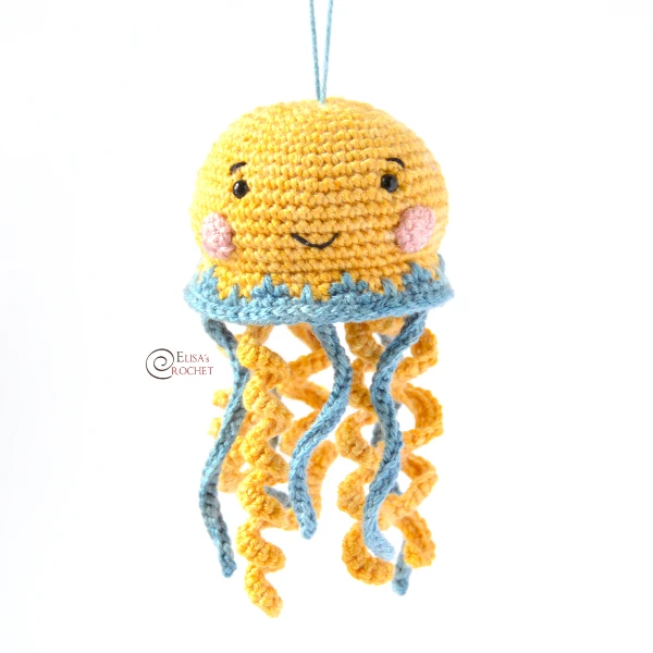 A yellow crochet jellyfish with cute rosy cheeks.