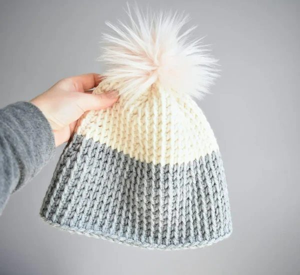 A colourblocked, grey and white Tunisian crochet hat.