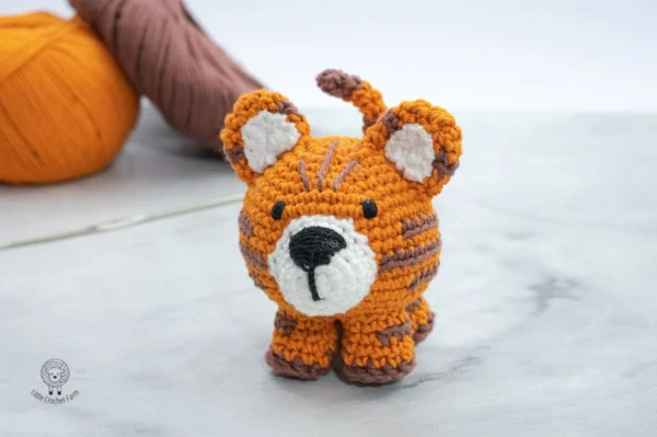 A standing amigurumi tiget with an oversized head.
