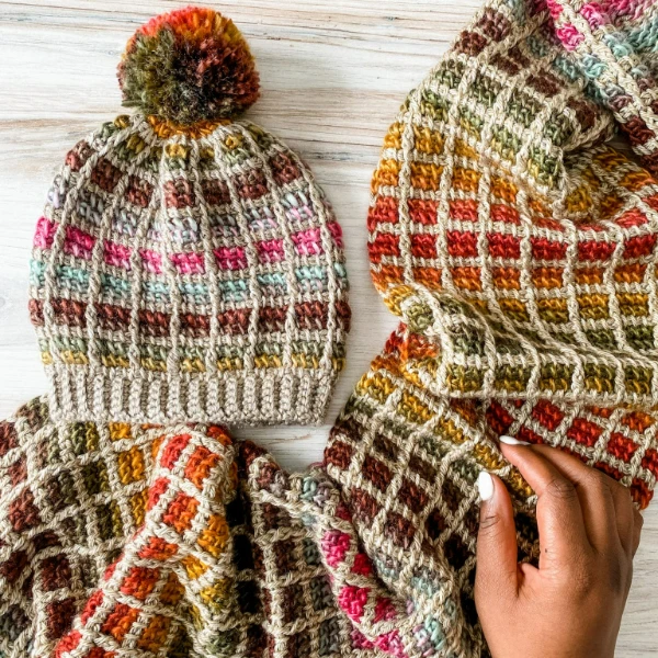 A flat-lay image of a Tunisian crochet hat and matching scarf.