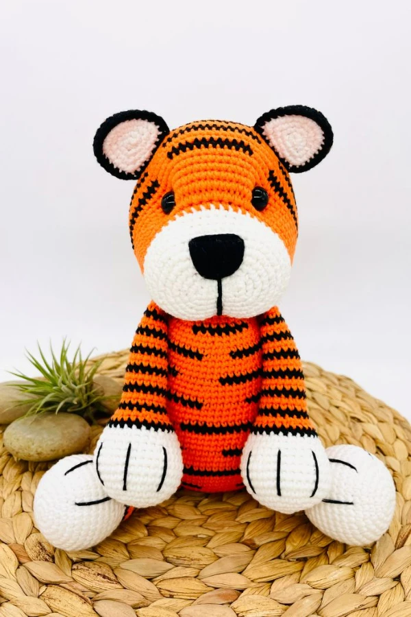 A crochet tiger plushie in a seated position.