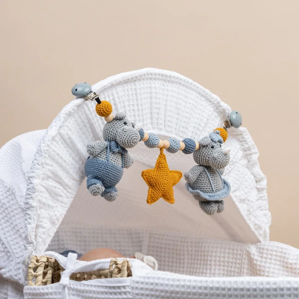 A crochet stroller chain featuring toy rhinos.