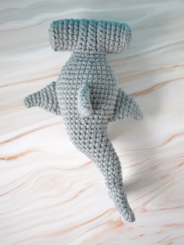 A top view of a crochet hammerhead shark amigurumi.