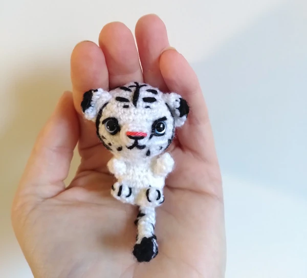 A mini white tiger amigurumi toy.